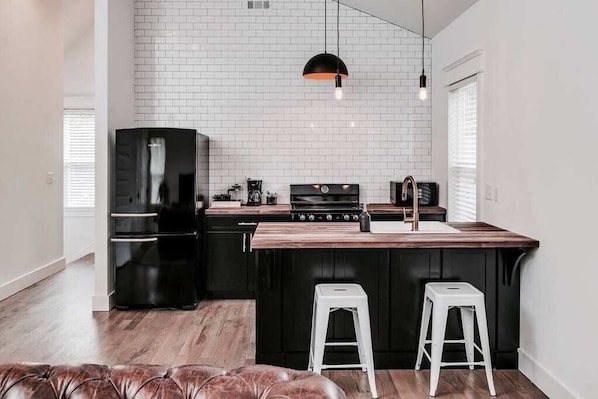 Fully stocked kitchen with subway backsplash, GE Artistry appliances and custom cabinets