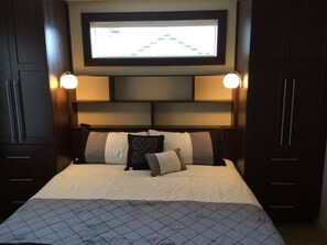 King Sized Bed with Flanking Closets and 32" Smart TV