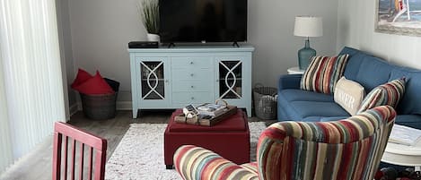 Living area with cable TV, sleeper sofa, books, and games.