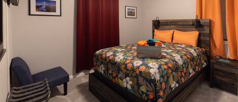 Relax in our front bedroom with queen bed, tv and device chargers.