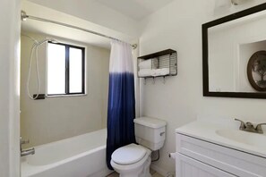 Spacious bathroom with a tub. Shampoo, body wash and conditioner provided