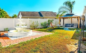 Outdoor Gazebo with seating and fire place, hammock, and water fountain