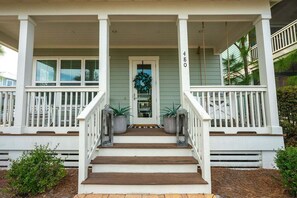 Step into relaxation on this charming front porch, adorned with greenery and cozy seating to greet you after a day of adventure.
