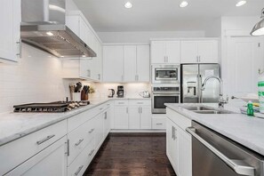 Whip up your favorite meals in this fully equipped kitchen featuring stainless steel appliances, sleek countertops, and plenty of prep space.