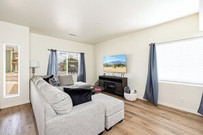 Living room with electric fireplace and 65 inch smart TV. Lots of comfy blankets for those cold winter evenings