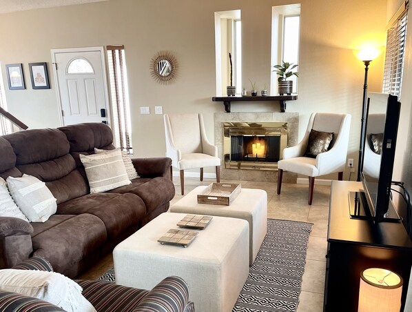 Living room with double reclining couch, TV, and fireplace