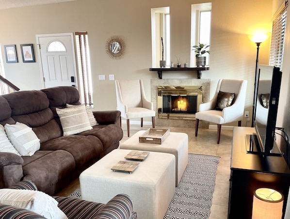 Living room with double reclining couch, TV, and fireplace