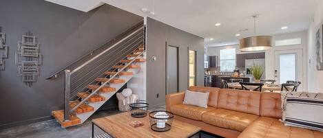 Staircase | Open floor plan showcasing the living room, dining area and kitchen.