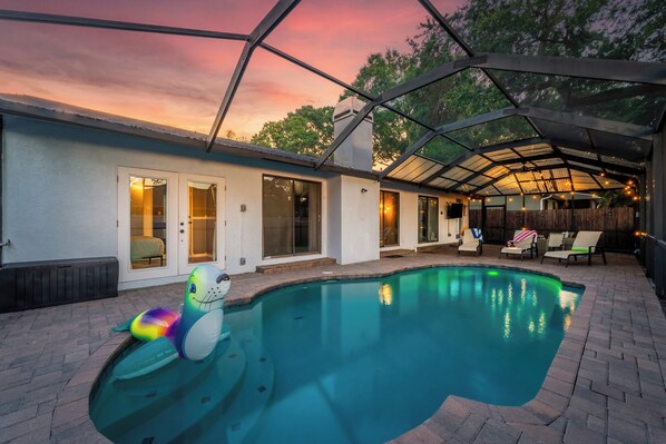 Sreened-in backyard oasis with a heated saltwater pool free from mosquitos.