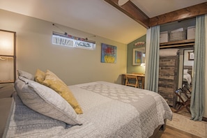 Queen sized bed with dresser, luggage rack, and full length mirror.