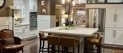 The updated kitchen seats 8 with an oversized dining bar of natural stone. 