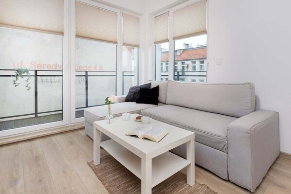 Living room with a comfortable sofa, TV, kitchenette and exit to the balcony