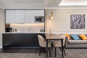 A modern kitchen with sleek cabinets, a dining table, and an open-plan design.
