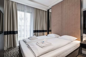 A bedroom with a large comfortable bed, soft lighting, and modern decor.