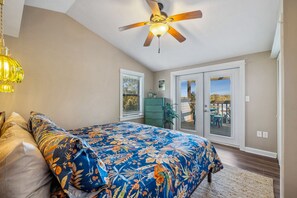The bedroom has a king bed and views of the bay over the deck