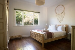 The first queen bedroom is peaceful and bright with a soft, earthy palette—ideal for slow mornings and restful nights.