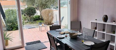 Coin séjour en véranda donnant sur une grande terrasse et jardinet.