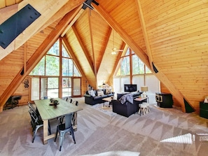 Massive great room with three large a-frame windows and bright cathedral ceilings.