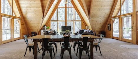 Large dining table to gather for family dinners and game nights! Cathedral ceilings with triple a-frame windows.