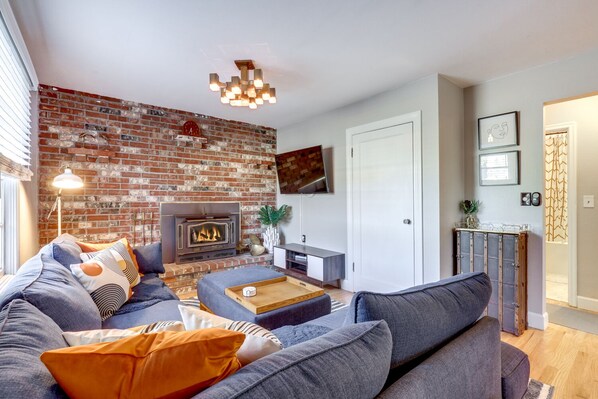 Living room with fireplace, TV, & blue tooth sound bar.