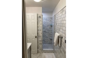 Marble-tiled bathroom with walk in shower and heated floors