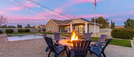 Large gas fire pit next to heated pool.