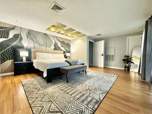 Master bedroom with a king bed and mural wall.