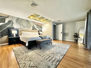 Master bedroom with a king bed and mural wall.