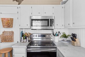 Quaint coastal kitchen with stainless steel appliances and fully stocked