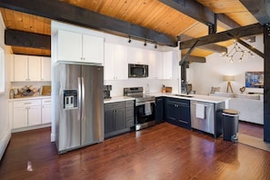 Fully-stocked kitchen with a small bar area behind. The full laundry room and half-bath are also located behind.