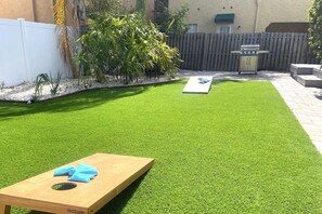 Fresh new turf and a game of cornhole out back