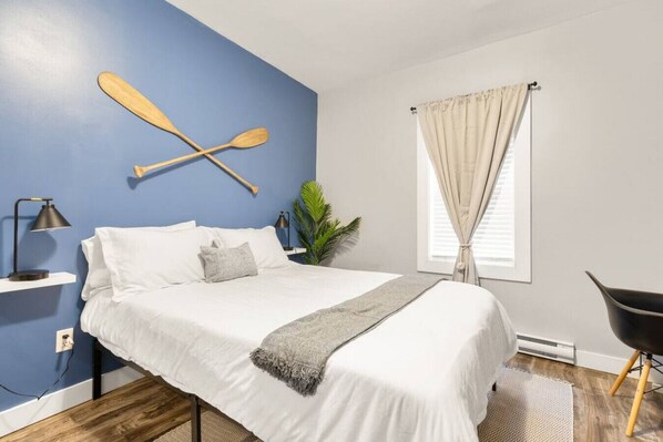 Lacrosse inspired bedroom with queen bed, premium linens, pillows, and blackout curtains.