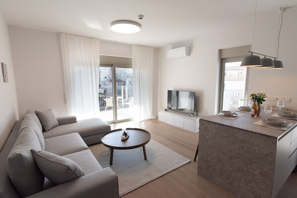 Bright living room with a comfortable sofa and TV with Netflix 