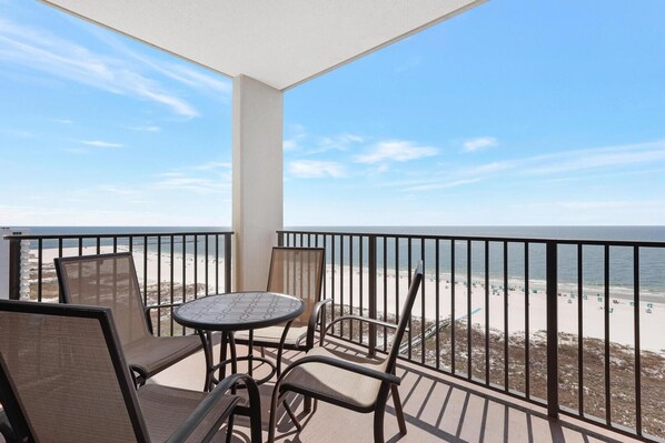 Step onto the balcony furnished with a table and chairs, offering a serene outdoor retreat perfect for enjoying meals, sipping drinks, or simply soaking in the fresh air and scenic beach views.