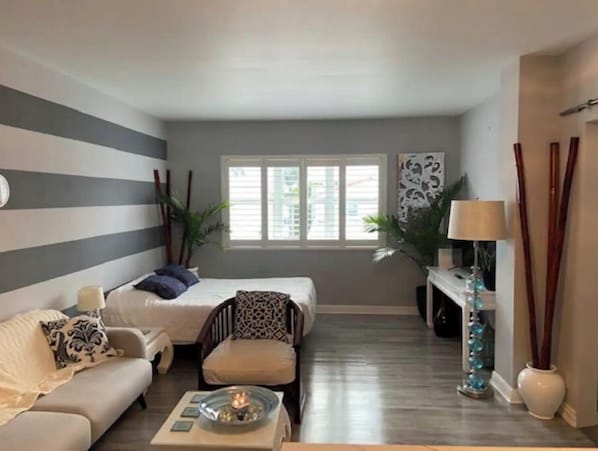 Living room with queen size bed and large screen TV.