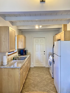 Seaglass's Well outfitted kitchen with wood cabinets and granite counters