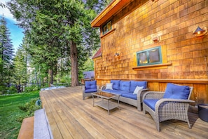 Side deck with lounge chairs looking out over the yard. 