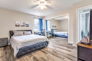 Featuring a Plush Queen Size Bed, Dedicated Workspace, Nightstand, & Smart TV