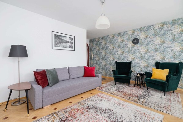 A bright living room with a gray sofa, colorful cushions, and a stylish yellow chair.

