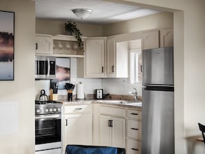 Fully-stocked kitchen with stove/oven, microwave, and dishwasher