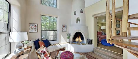 A room with a fireplace and a staircase.