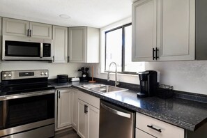 Full kitchen with dishwasher, microwave, stove and fridge.