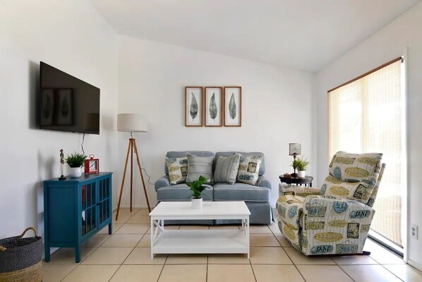 Cozy living room with sofa, recliner and Smart TV.