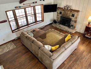 The living area features a fire place, smart TV, and window onto the front porch