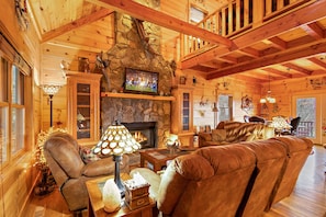 Exposed Wood Beams, Wood Floors, Leather Sofas, and Stone Gas Log Fireplace