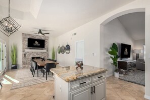 Open concept kitchen and dining with TV and fireplace