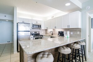 Full kitchen with plenty of extra seating at the bar. New cabinets + countertops