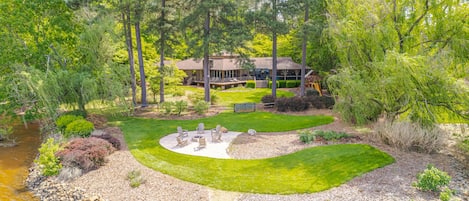Stunning fenced back yard, fire pit, and stone steps leading into the lake