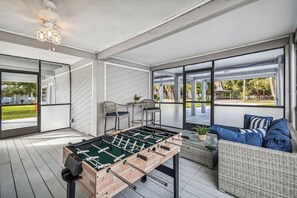 Chill out in a screened-in game room w/ ceiling fan, bar table, patio furniture.