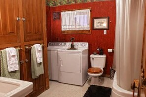 Washer and dryer unit in the bathroom. Stand up shower with tub.